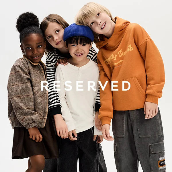 Czwórka uśmiechniętych dzieci w modnych ubraniach.