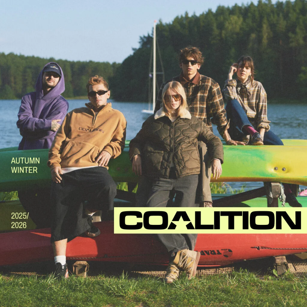 Grupa młodych ludzi siedzących na kajakach nad jeziorem.