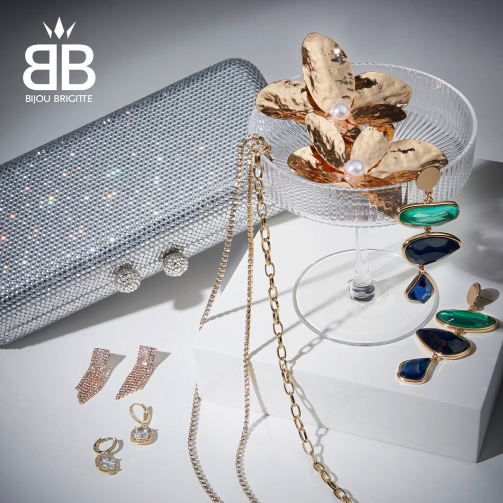 Elegancka biżuteria i akcesoria na tle srebrnej torebki.