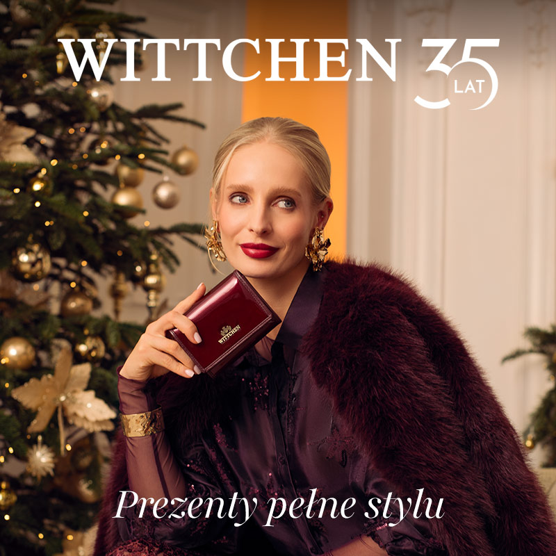 Kobieta z eleganckim portfelem na tle choinki.