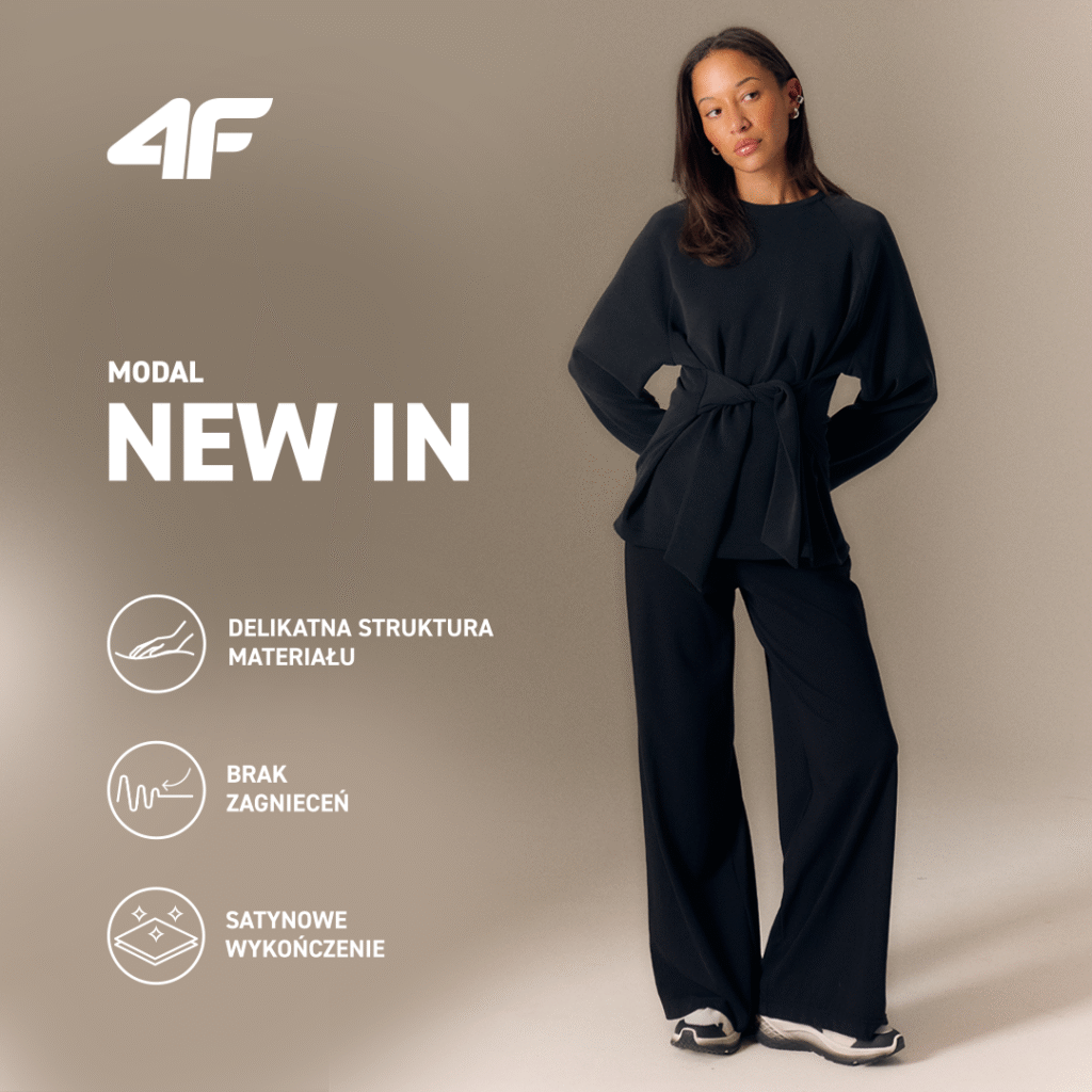 Kobieta w modnym czarnym stroju z napisem 'NEW IN'.