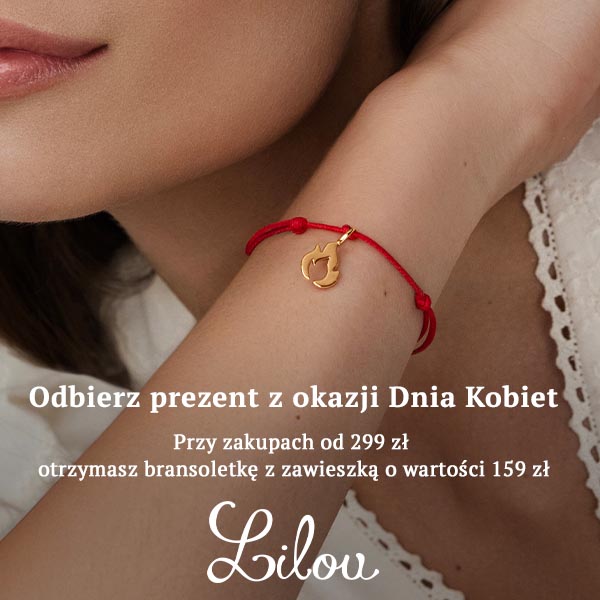Bransoletka z czerwoną nicią i złotą zawieszką na nadgarstku.