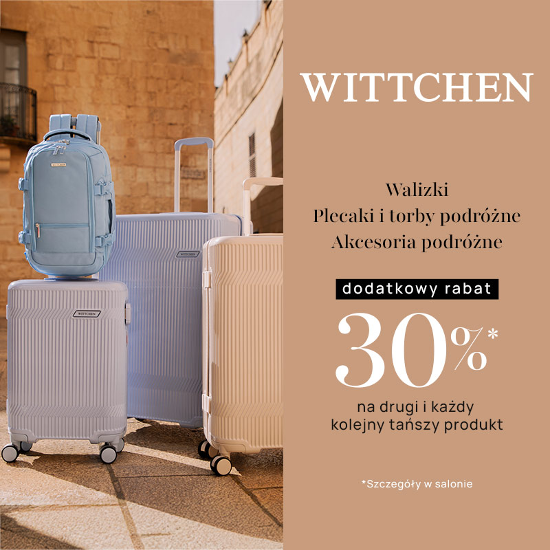 Zestaw walizek i plecak na tle kamiennego budynku.