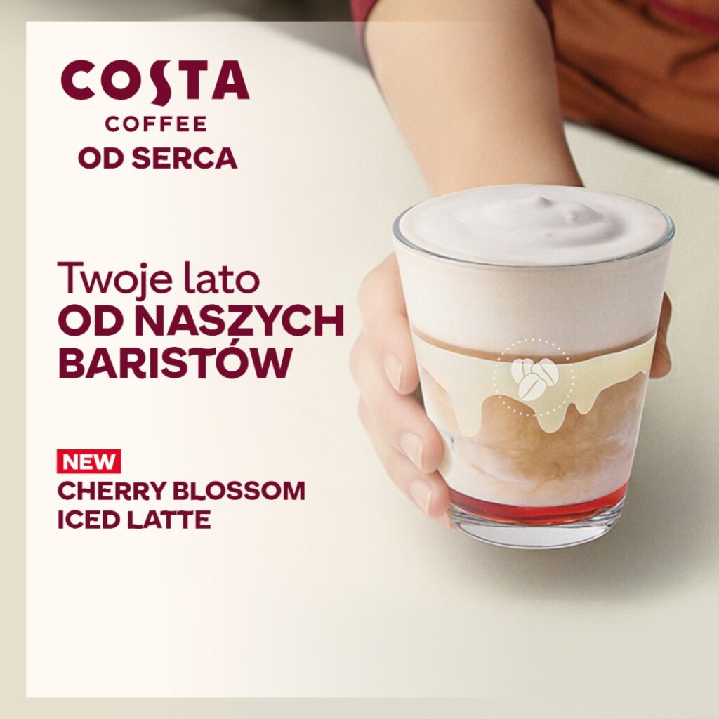 Szklanka latte z pianką i syropem wiśniowym.